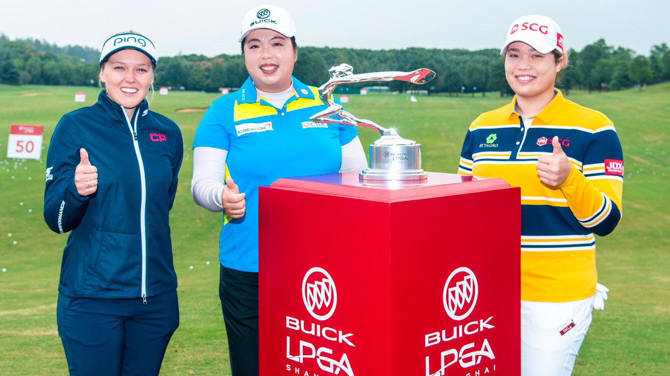 Brooke Henderson (left) and Ariya Jutanugarn (right) join Shanshan Feng in front of the Buick LPGA Shanghai trophy