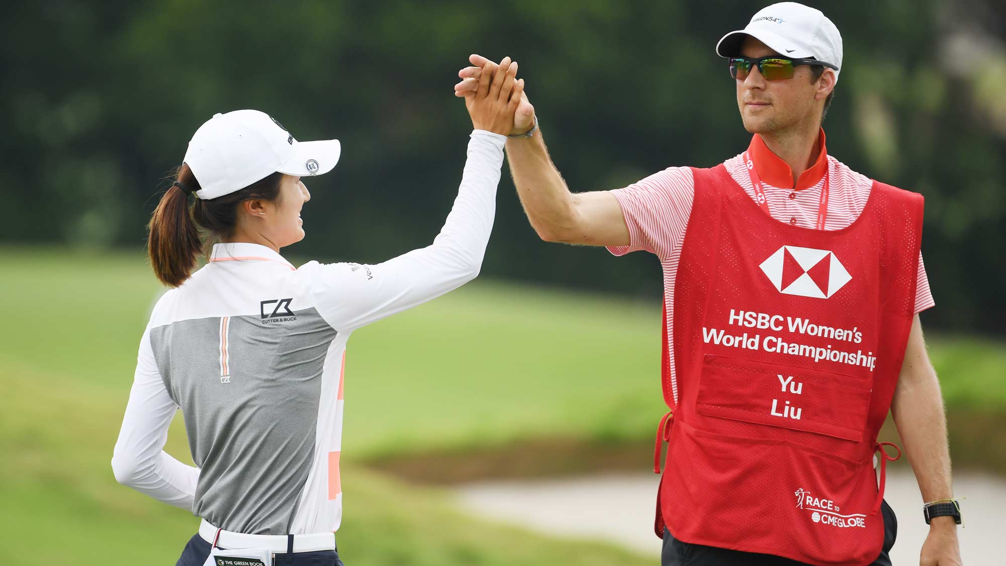 Yu Liu of China celebrates with her caddie on the 18th hole during the first round of the HSBC Women's World Championship at Sentosa Golf Club on February 28, 2019 in Singapore. 