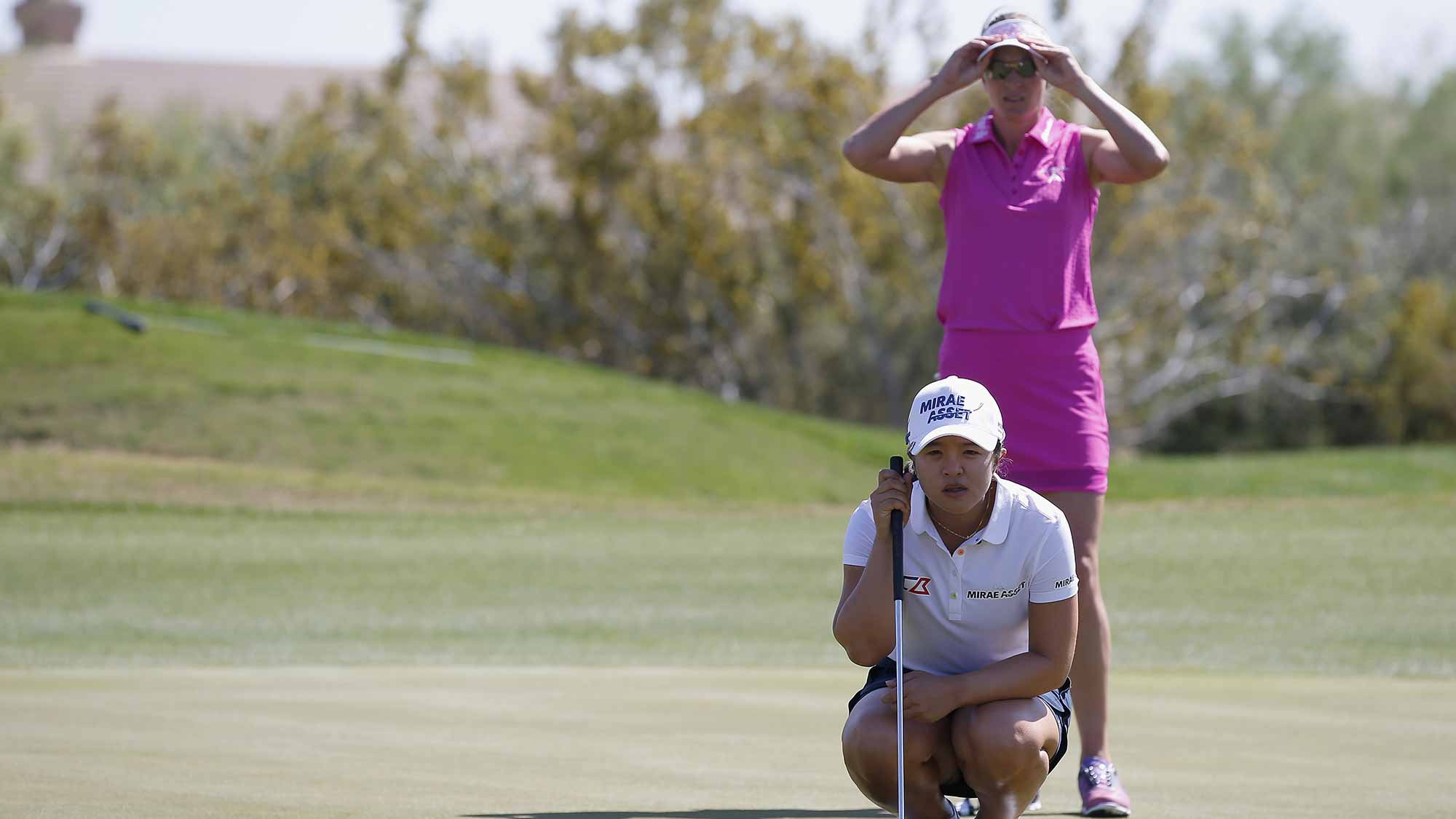 Sei Young Kim (in white) of South Korea and Brittany Lang (in pink) line up their putts on the first green during the third round of the LPGA JTBC Founders Cup at Wildfire Golf Club