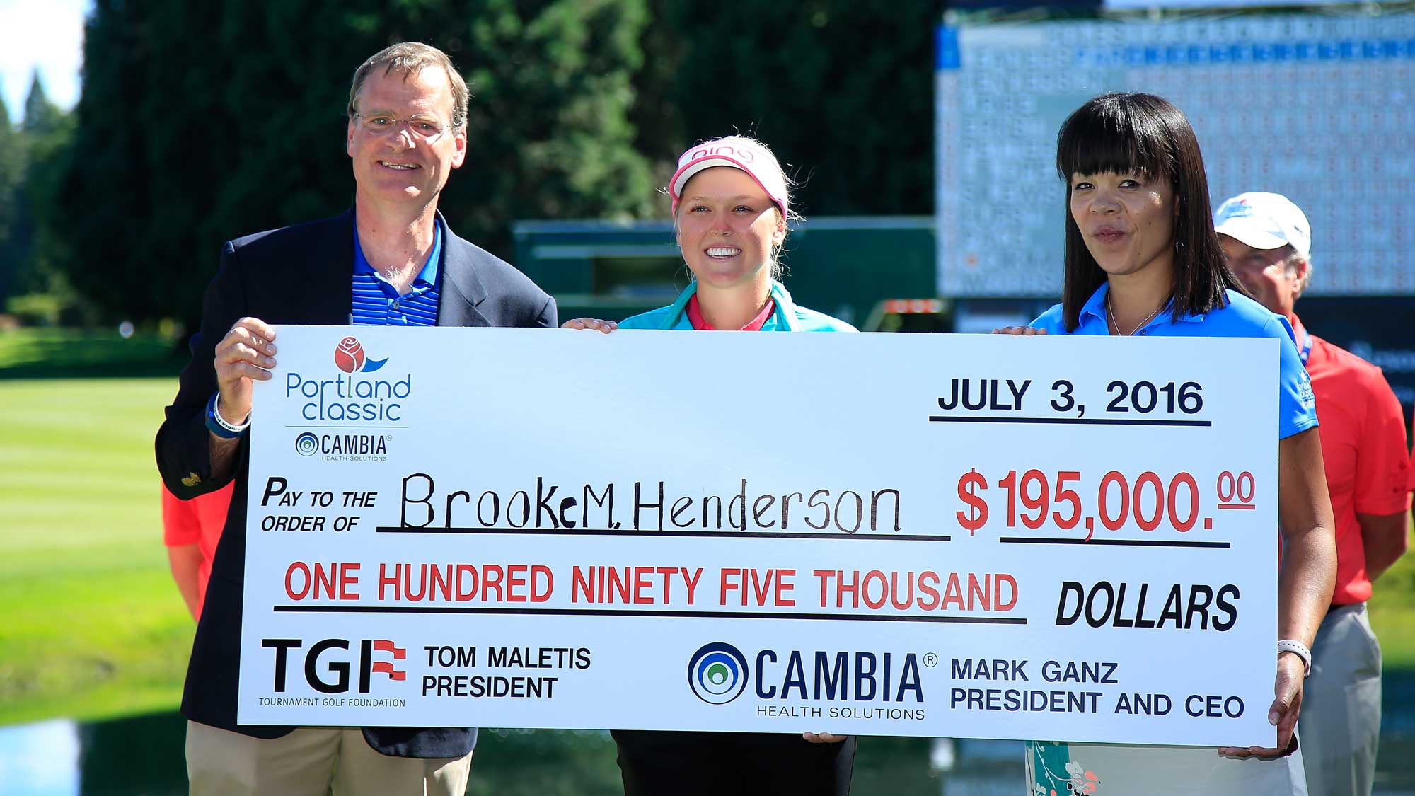Brooke M. Henderson of Canada (C) and Mark Ganz President and CEO of Cambia (L) hold the winner's check after the fourth and final round of the Cambia Portland Classic