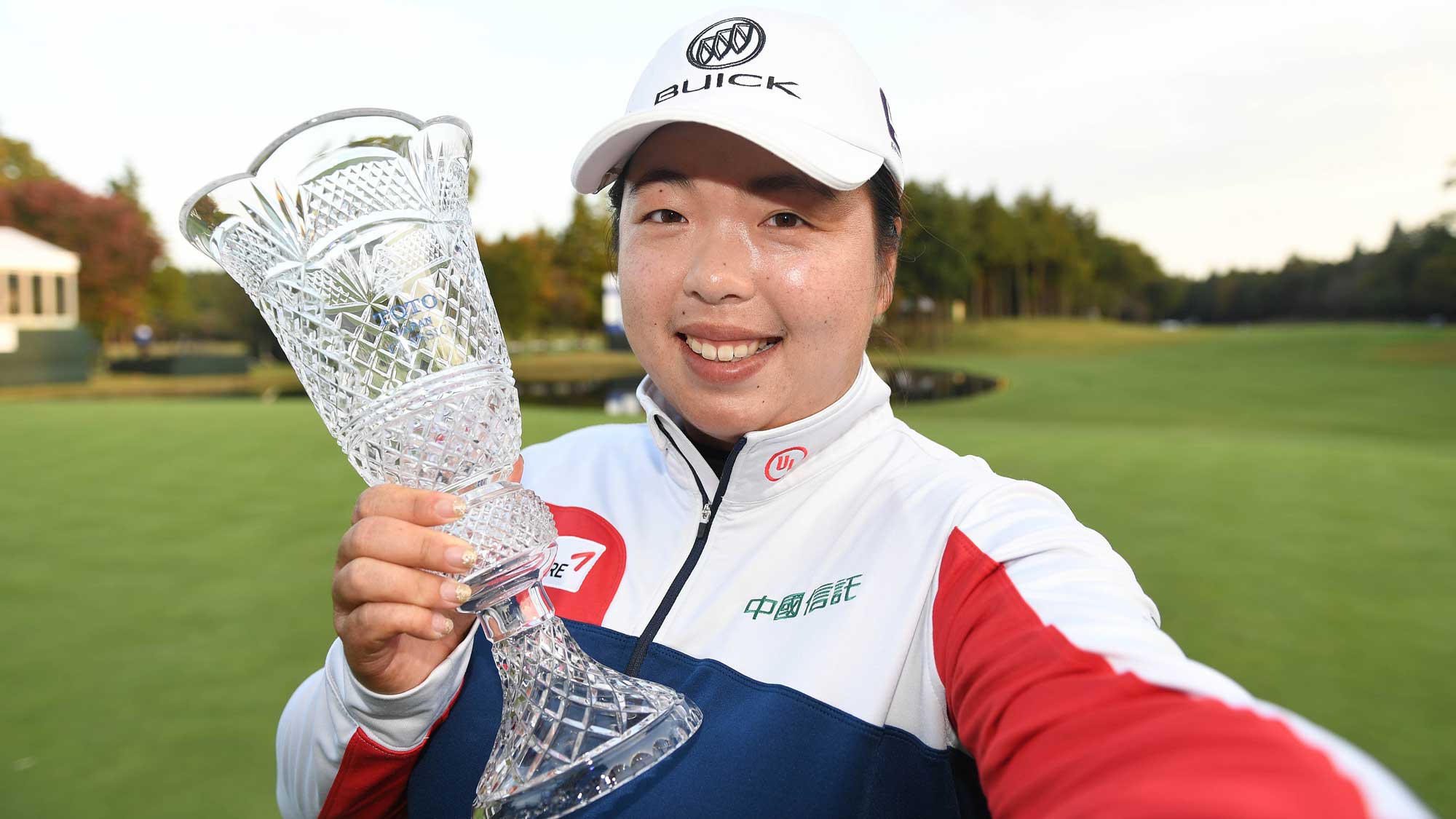 Shanshan Feng of China imitates a selfie as she poses with the trophy after winning the TOTO Japan Classic