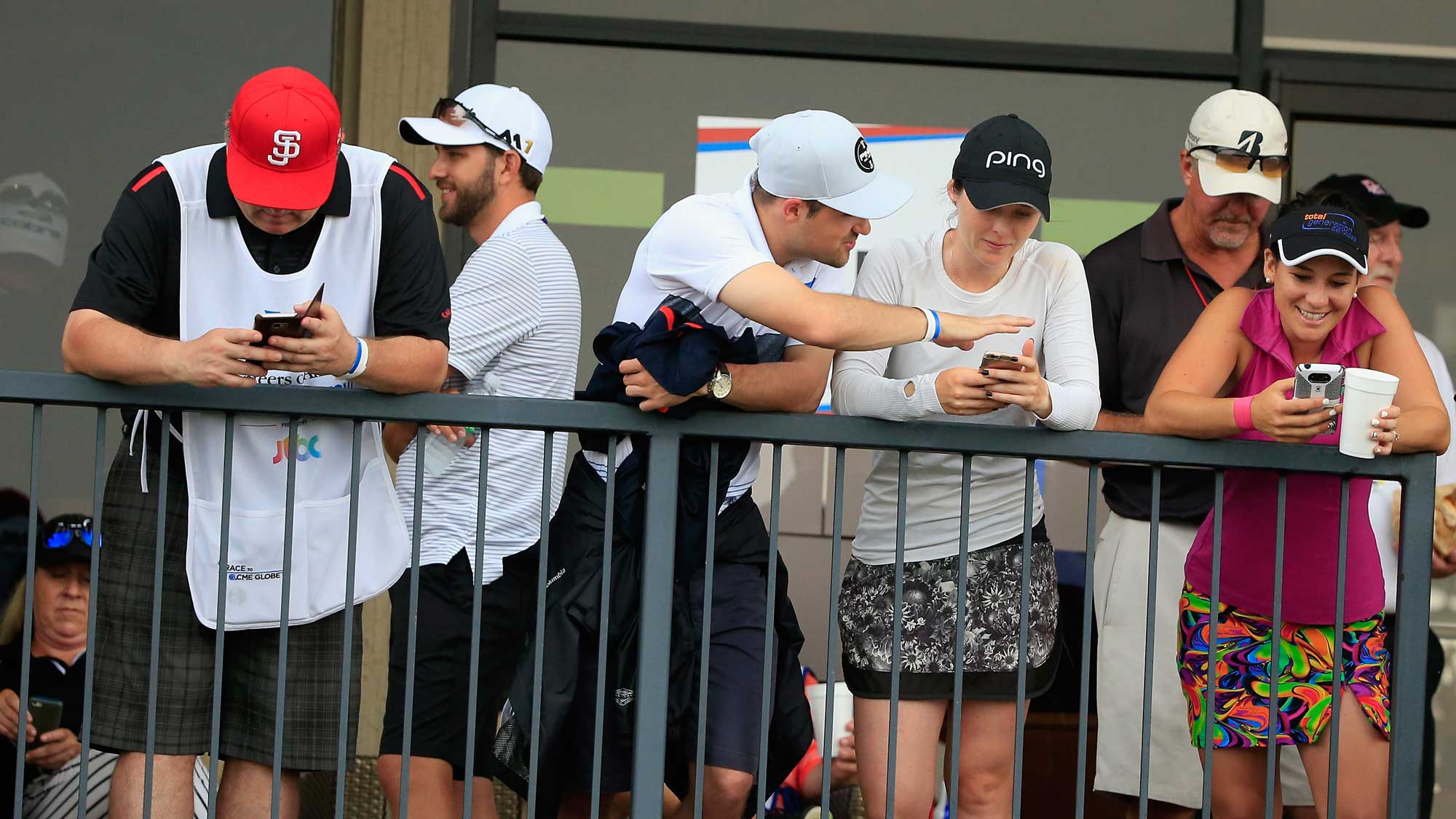 Players and caddies wait near the clubhouse after play was suspended by dangerous weather during the second round of the Volunteers of America Texas Shootout