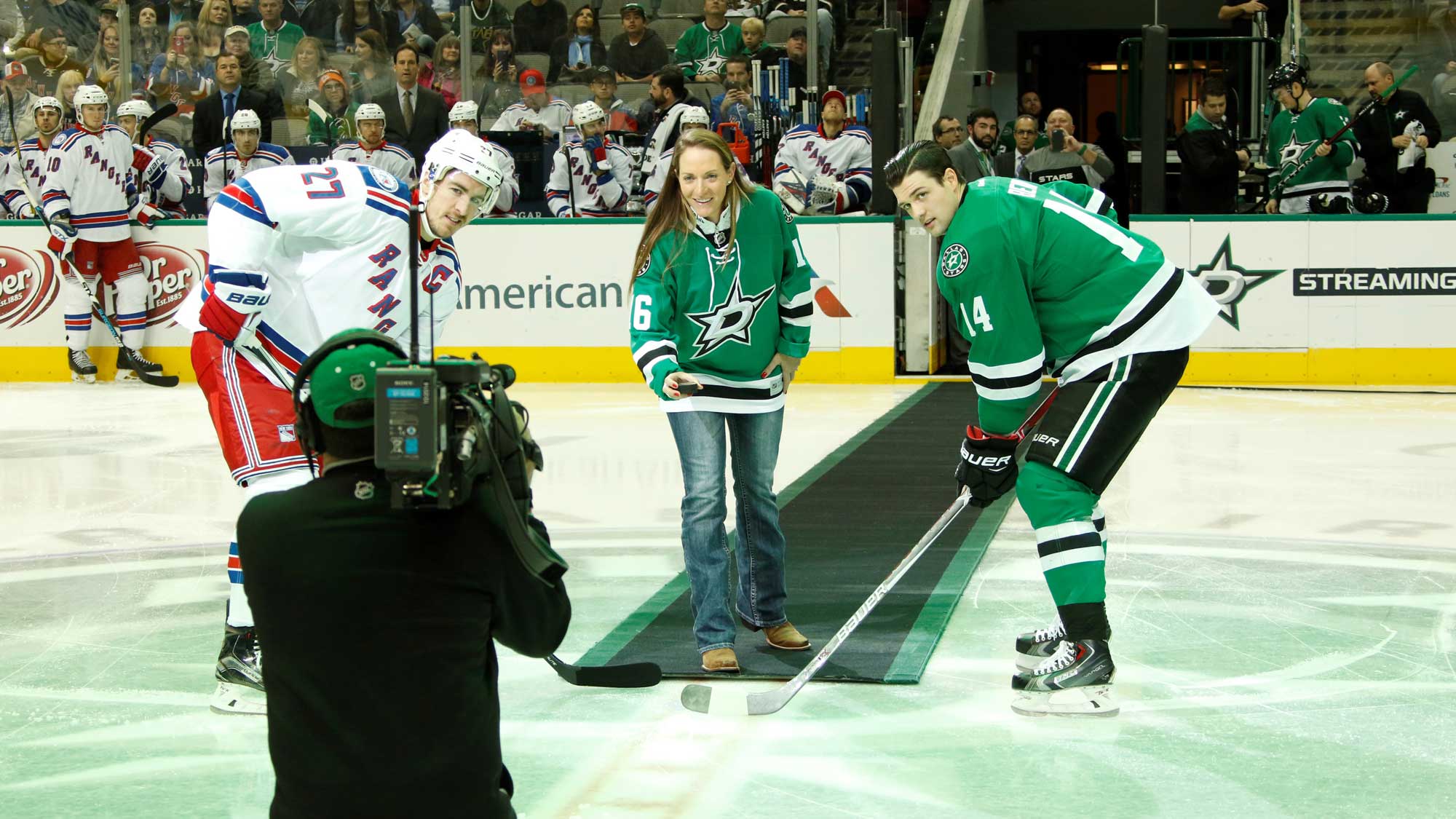 Brittany Lang with Stars captain Jamie Benn (right) and Rangers captain Ryan McDonough for the ceremonial puck drop 