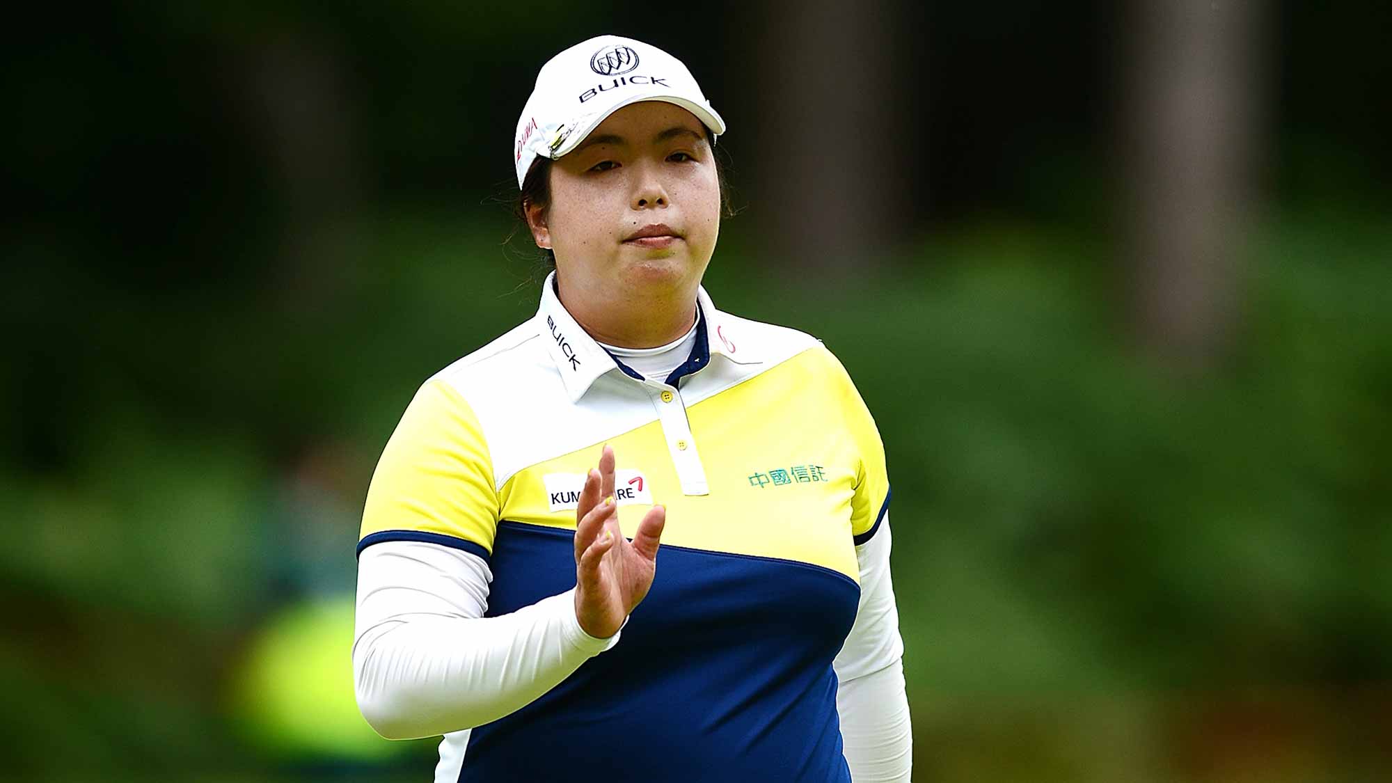 Shanshan Feng of China acknowledges the crowd on the 2nd green during the third round of the Ricoh Women's British Open at Woburn Golf Club