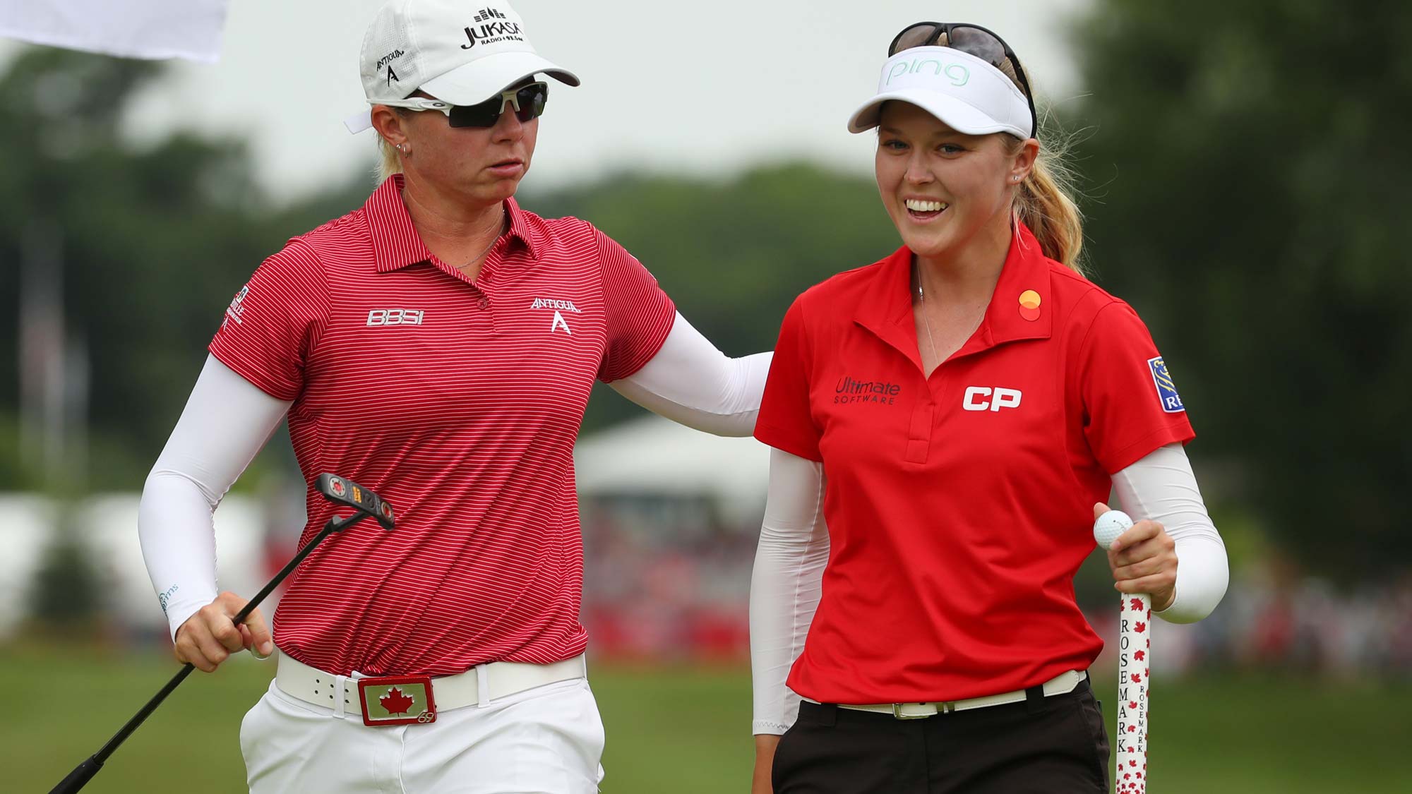 Teammates Brooke Henderson (R) and Alena Sharp walk off the first green during round two of the Dow Great Lakes Bay Invitational 