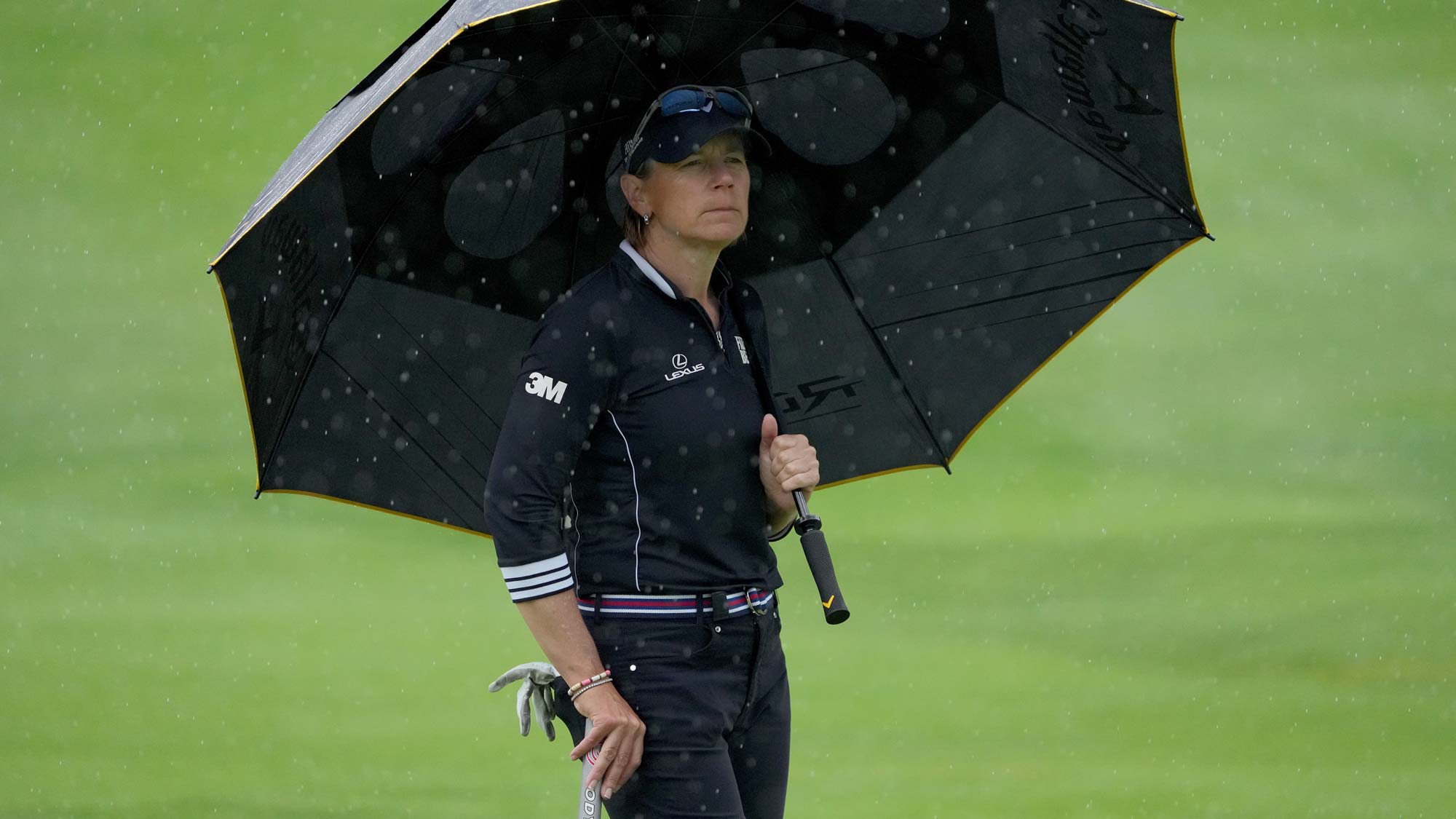 Annika Sorenstam of Sweden looks on from under an umbrella on the eighth green during the first round of the Dow Great Lakes Bay Invitational 