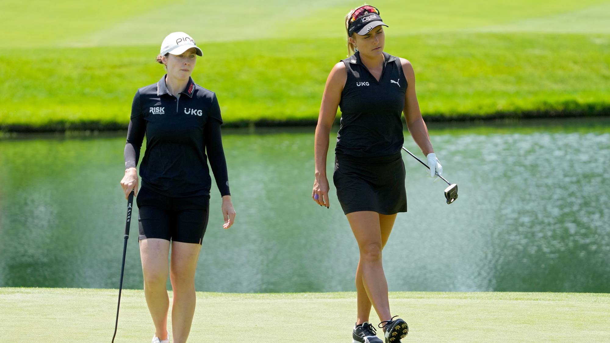 Brittany Altomare of the United States (L) and Lexi Thompson of the United States walk across the fifth green during the second round of the Dow Great Lakes Bay Invitational