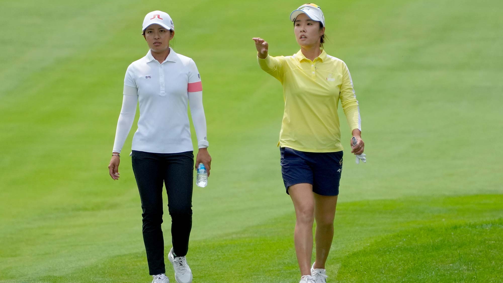 Tiffany Chan of Hong Kong (L) and Haeji Kang of South Korea walk across the fifth hole during the third round of the Dow Great Lakes Bay Invitational