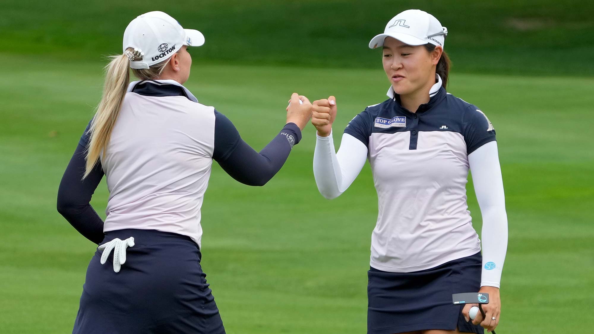 Matilda Castren of Finland (L) and Kelly Tan of Malaysia celebrate after making birdie on the eighth green during the final round of the Dow Great Lakes Bay Invitational