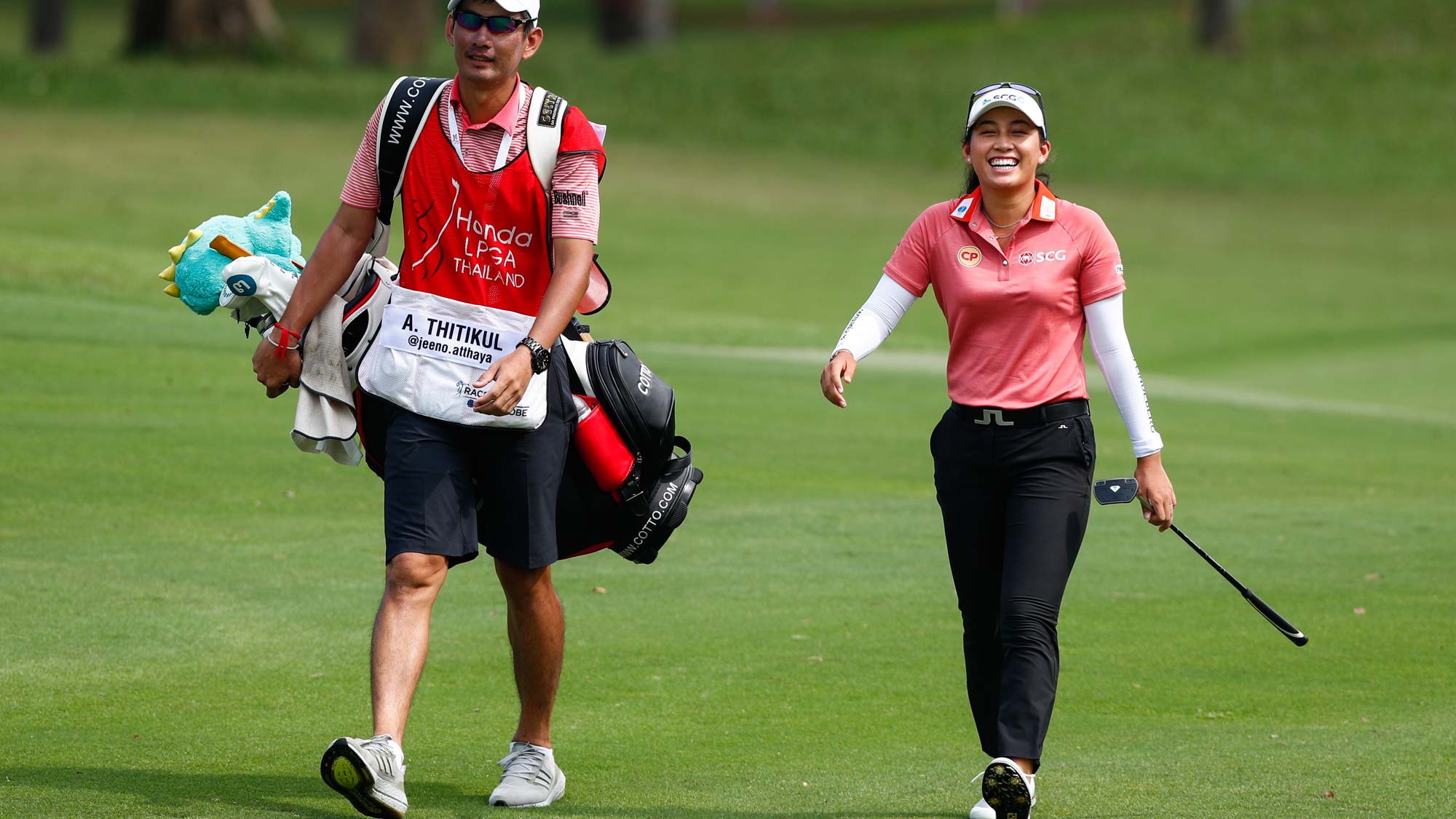 Atthaya Thitikul of Thailand reacts as she walks with her caddie after playing her second shot on the 1st hole during the first round of Honda LPGA Thailand