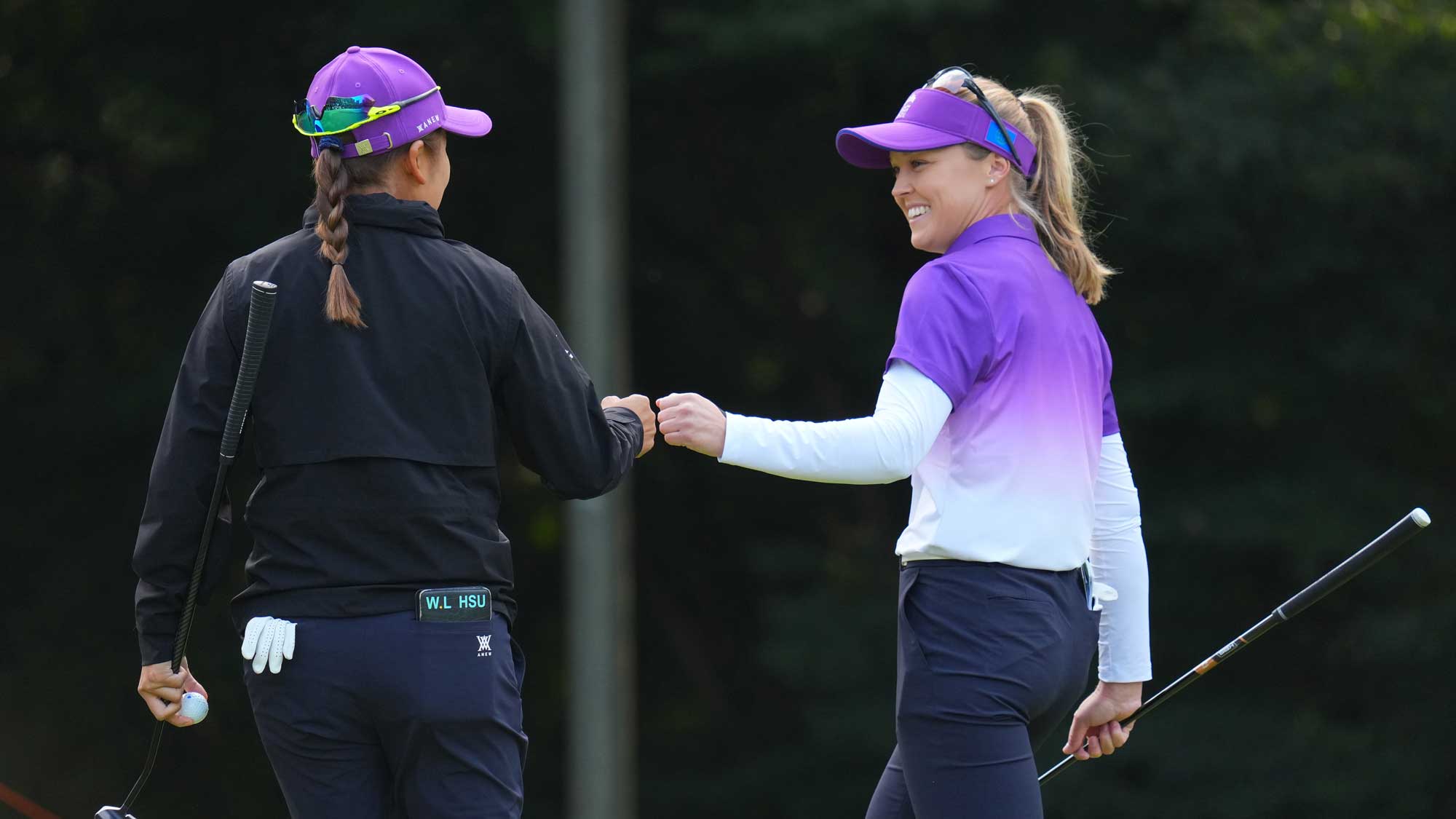 Wei-Ling Tsu (L) of the World Team fist bumps with her teammate Brooke M. Henderson