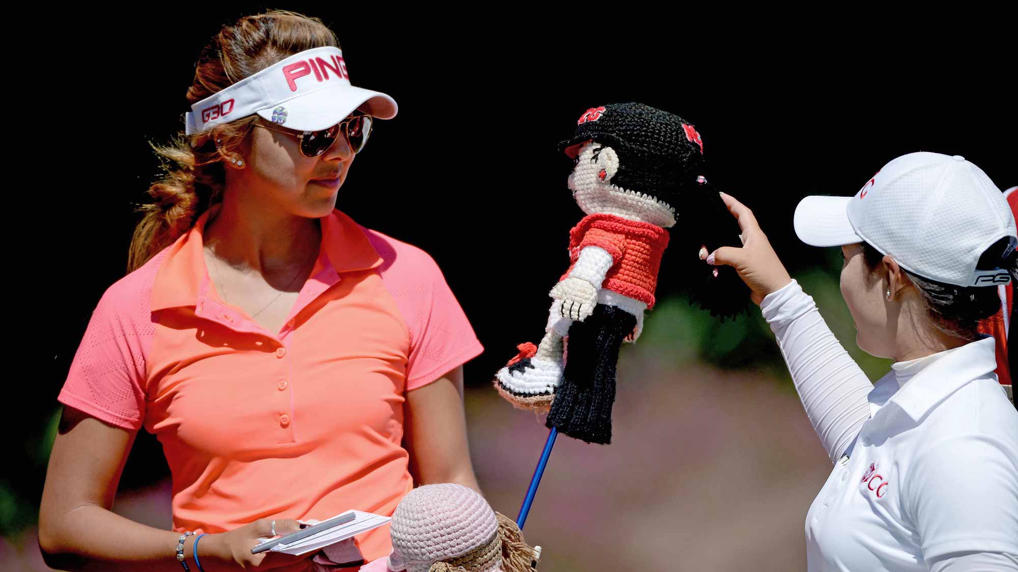 Alison Lee looks at a head cover with Moriya Jutanugarn of Thailand on the 18th hole during Round Two of the LPGA KIA Classic at the Aviara Golf Club