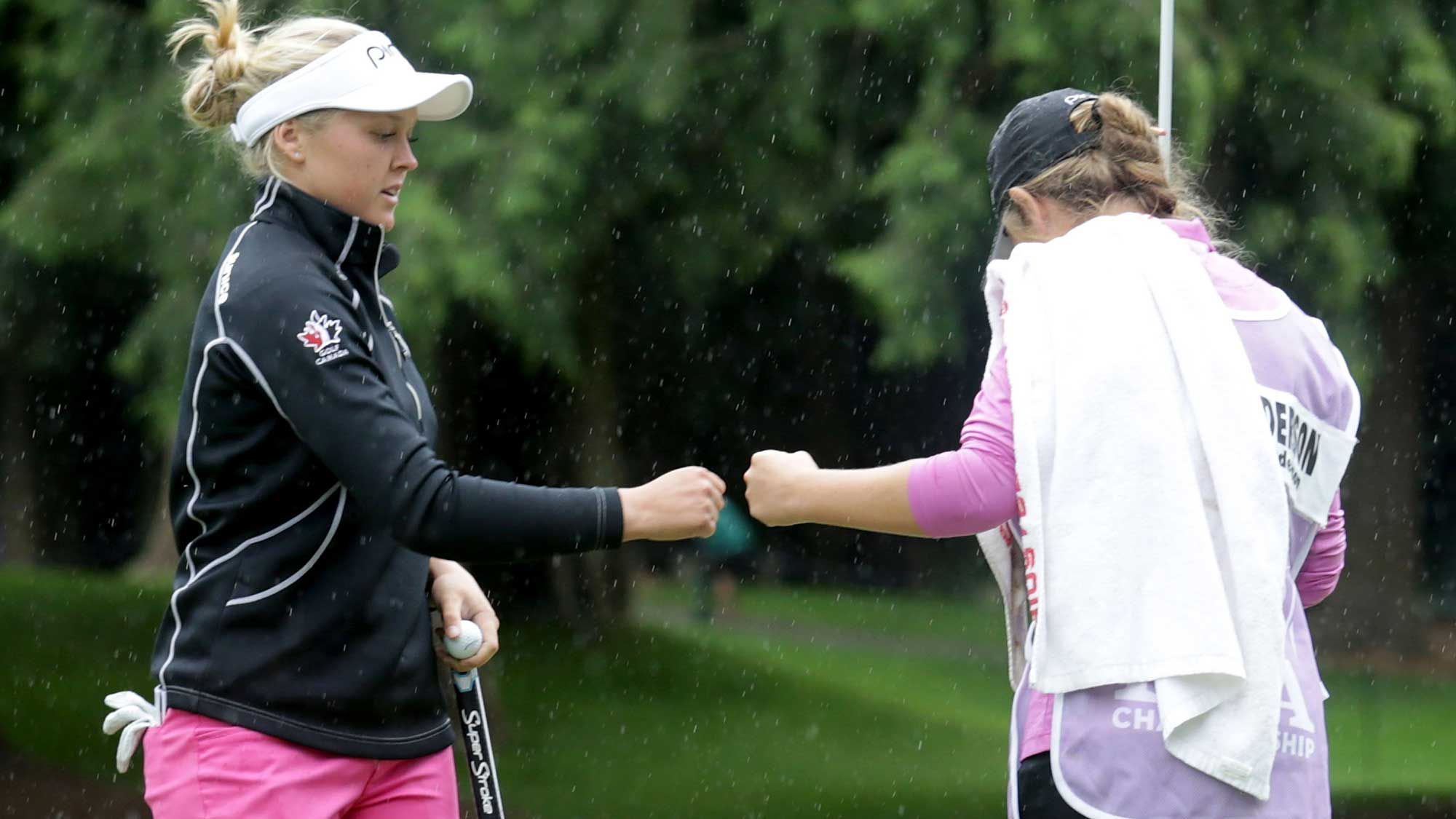 Brooke Henderson of Canada is congratulated by her sister/caddie Brittany after making a birdie putt on the ninth hole during the first round of the KPMG Women's PGA Championship