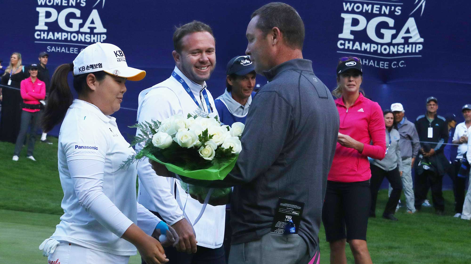 Inbee Park of South Korea is greeted with flowers on the 18th green by LPGA Tour commissioner Mike Whan after Park gained entry in the LPGA Hall of Fame after finishing the first round of the KPMG Women's PGA Championship