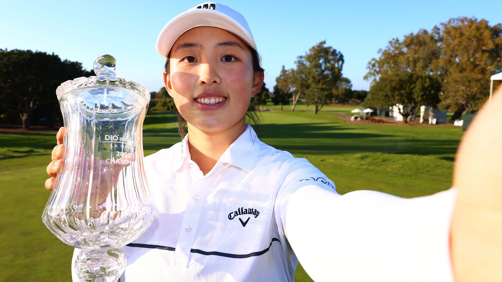 Ruoning Yin of China imitates a selfie as she poses with the trophy after winning the DIO Implant LA Open