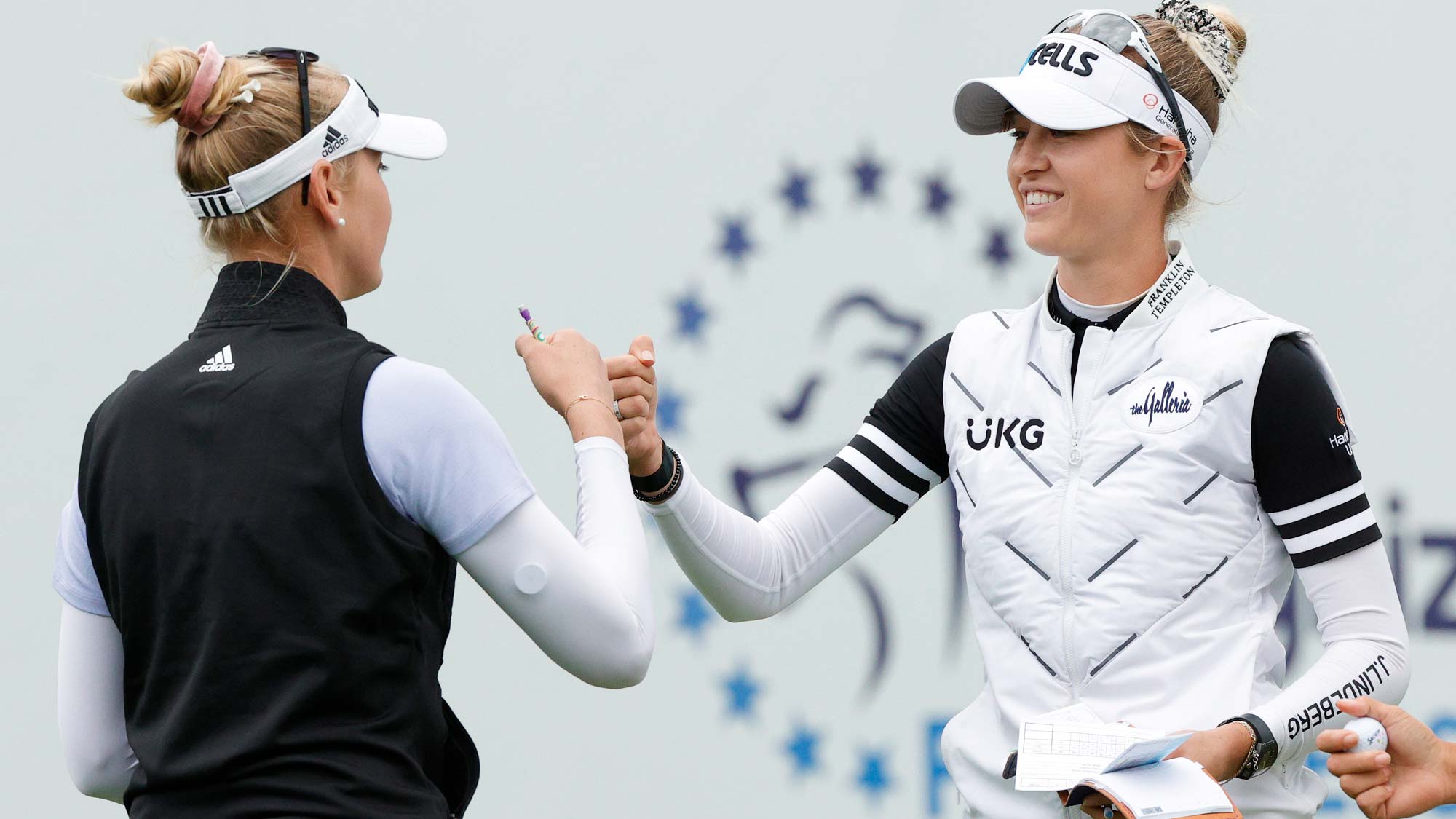 Nelly Korda of the United States (R) fist-bumps her sister Jessica Korda after both played the 18th hole during the third round of the Cognizant Founders Cup