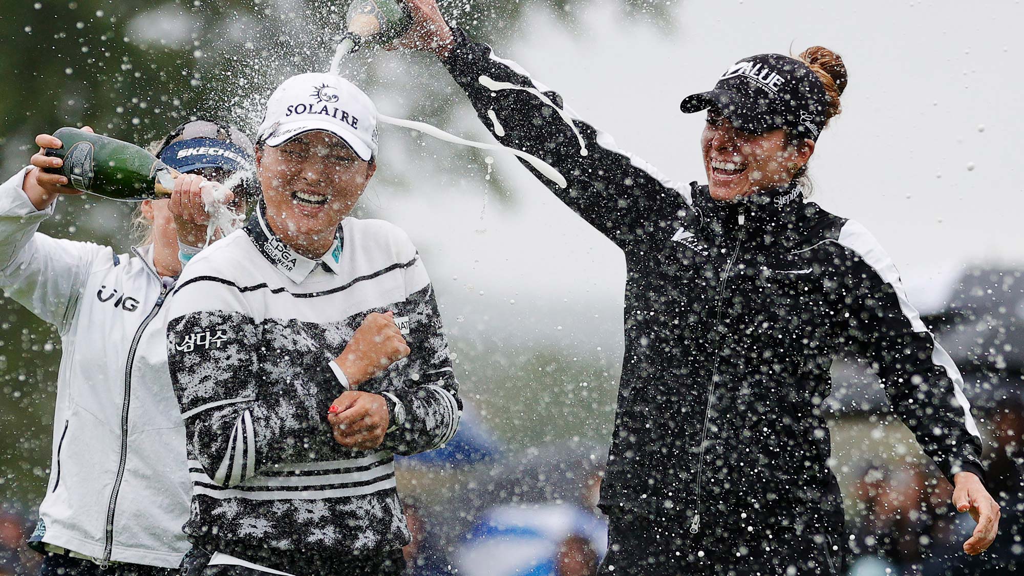 Gaby Lopez of Mexico (R) and Brooke M. Henderson of Canada (L) pour champagne on Jin Young Ko of Korea (C) after her win during the final round of the Cognizant Founders Cup
