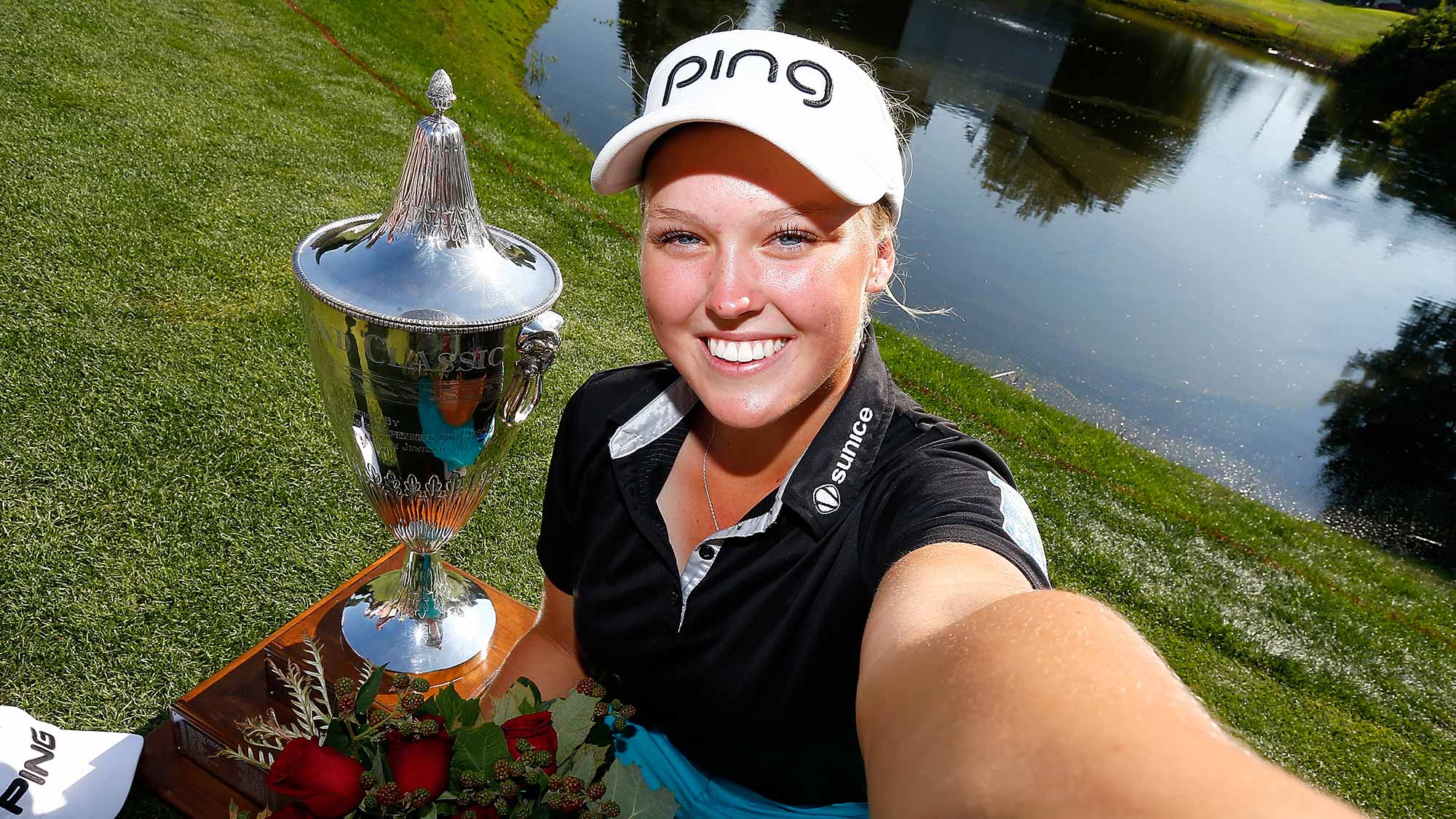 Brooke Henderson of Canada imitates a selfie with the trophy after her 21 strokes under par victory during the final round of the LPGA Cambia Portland Classic at Columbia Edgewater Country Club