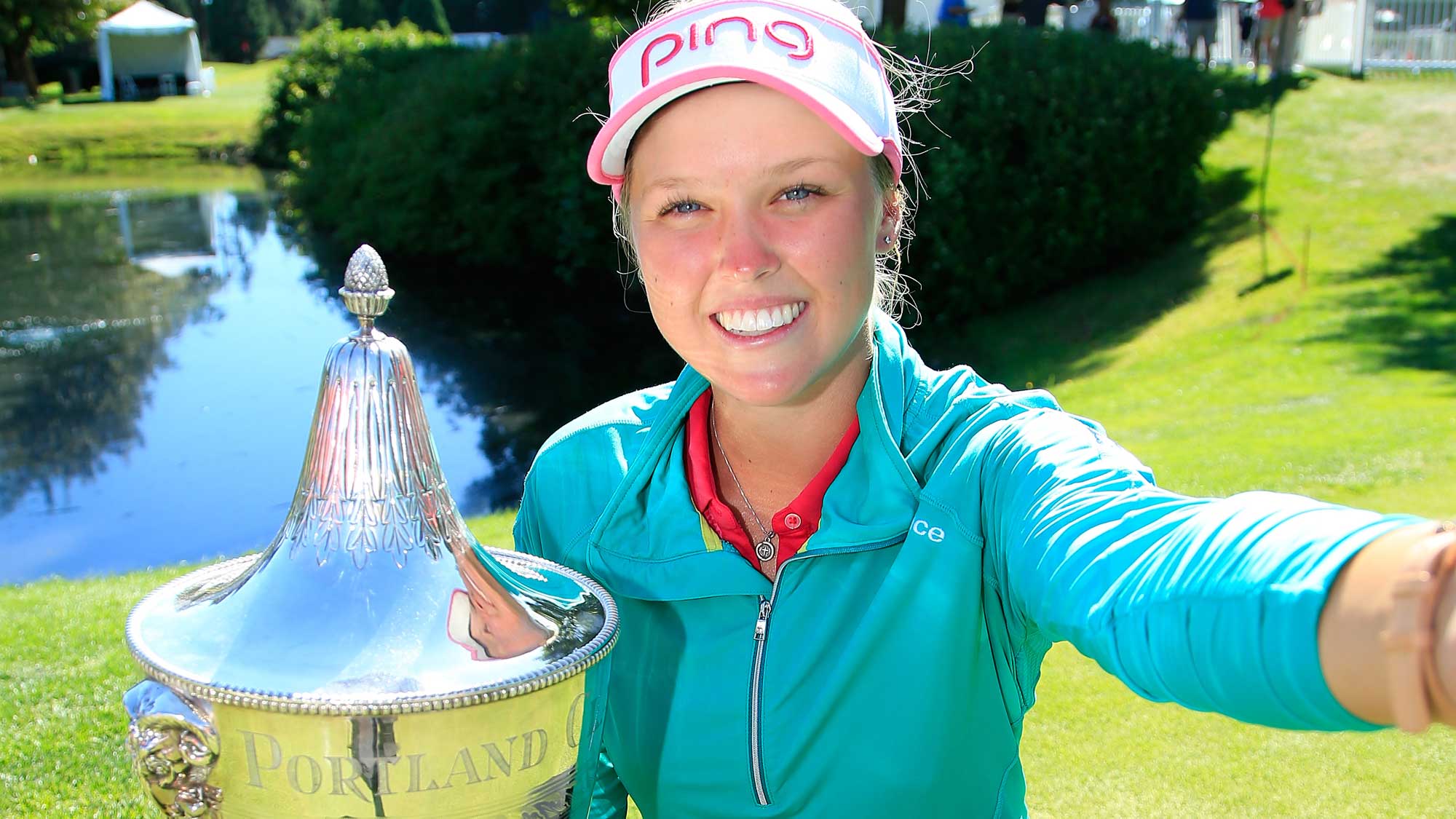 Brooke M. Henderson of Canada holds the trophy while posing for a selfie after winning the Cambia Portland Classic