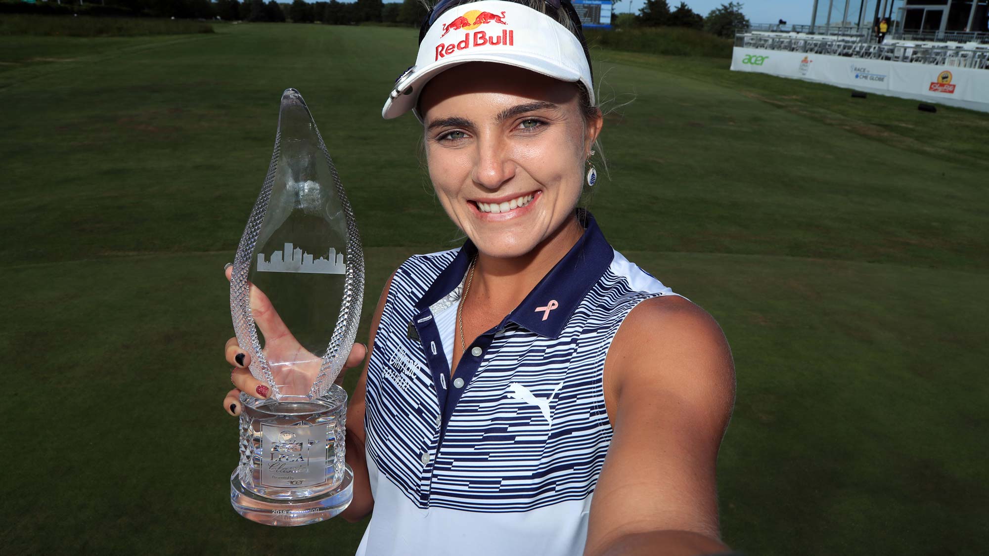 Lexi Thompson imitates a "selfie" as she holds the championship trophy after winning the ShopRite LPGA Classic presented by Acer