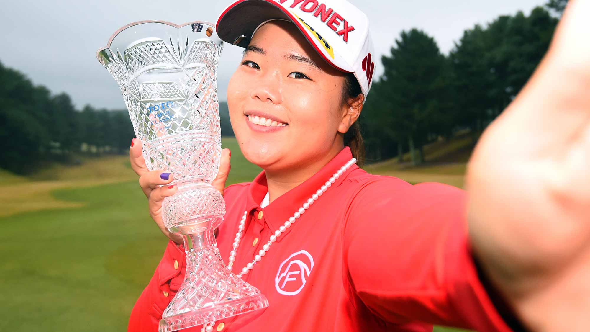 Sun-Ju Ahn of South Korea imitates a 'selfie' as she poses with the trophy after winning the TOTO Japan Classics 2015 at the Kintetsu Kashikojima Country Club