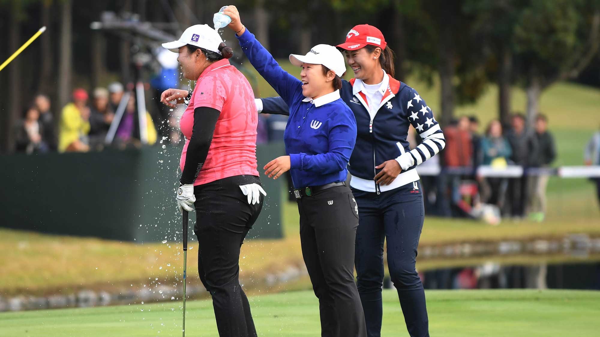 Shanshan Feng of China gets water dumped on her head by Jiyai Shin of South Korea and Xi Yu Lin of China in celebration after Feng won the TOTO Japan Classic