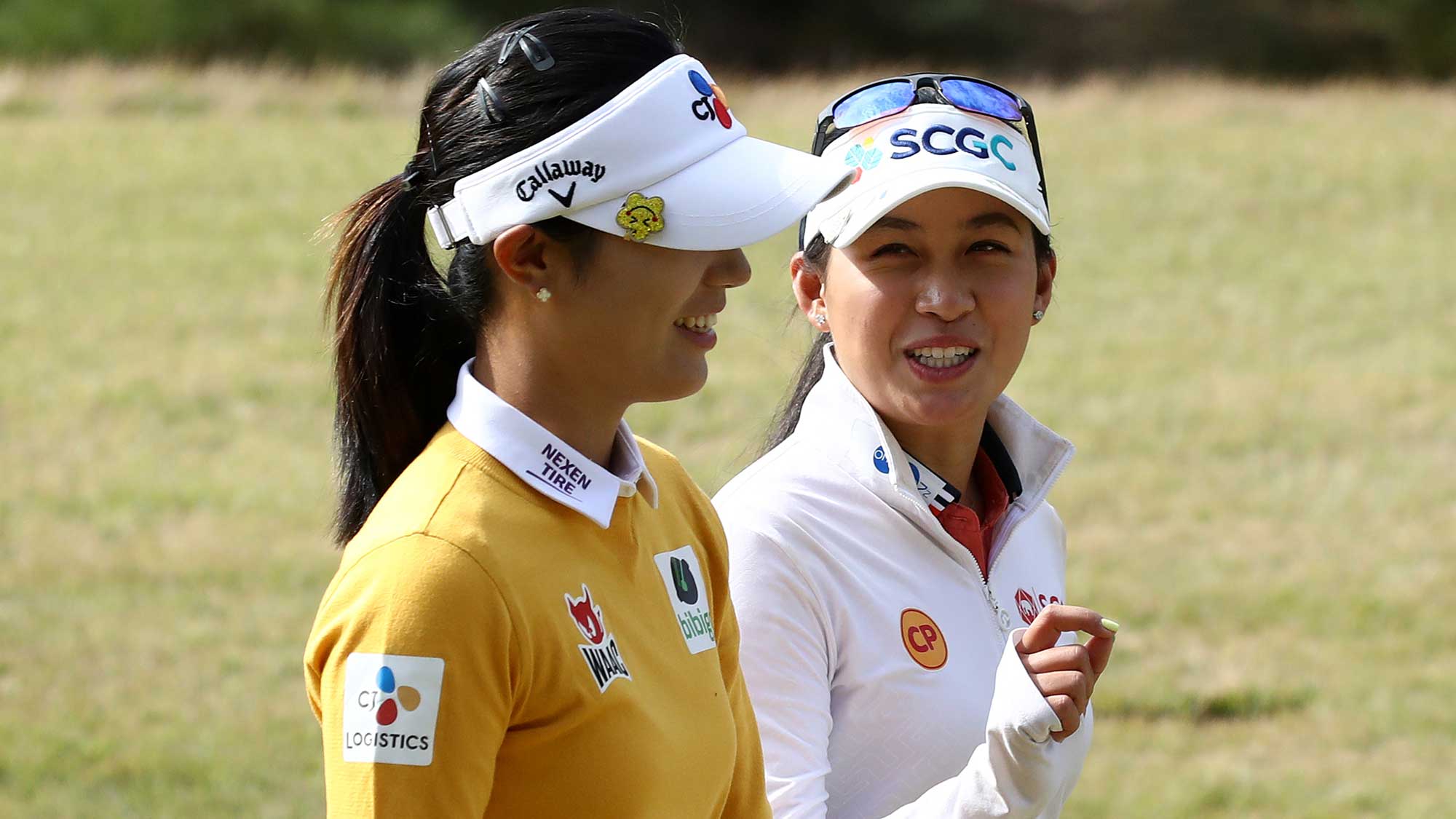 Atthaya Thitikul (R) of Thailand and Yaeeun Hong of South Korea chat as they walk on the ninth fairway during the second round of the BMW Ladies Championship